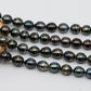 Tahitian Pearl drop shape full strand on top of a circle wood.