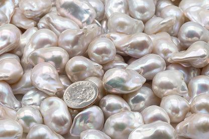 US dime coin on top of a bunch of loose baroque pearls.