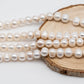 Strands of Freshwater Pearl large hole display on top of a circle wood.