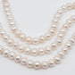 Displaying 3 strands of white large hole pearls.