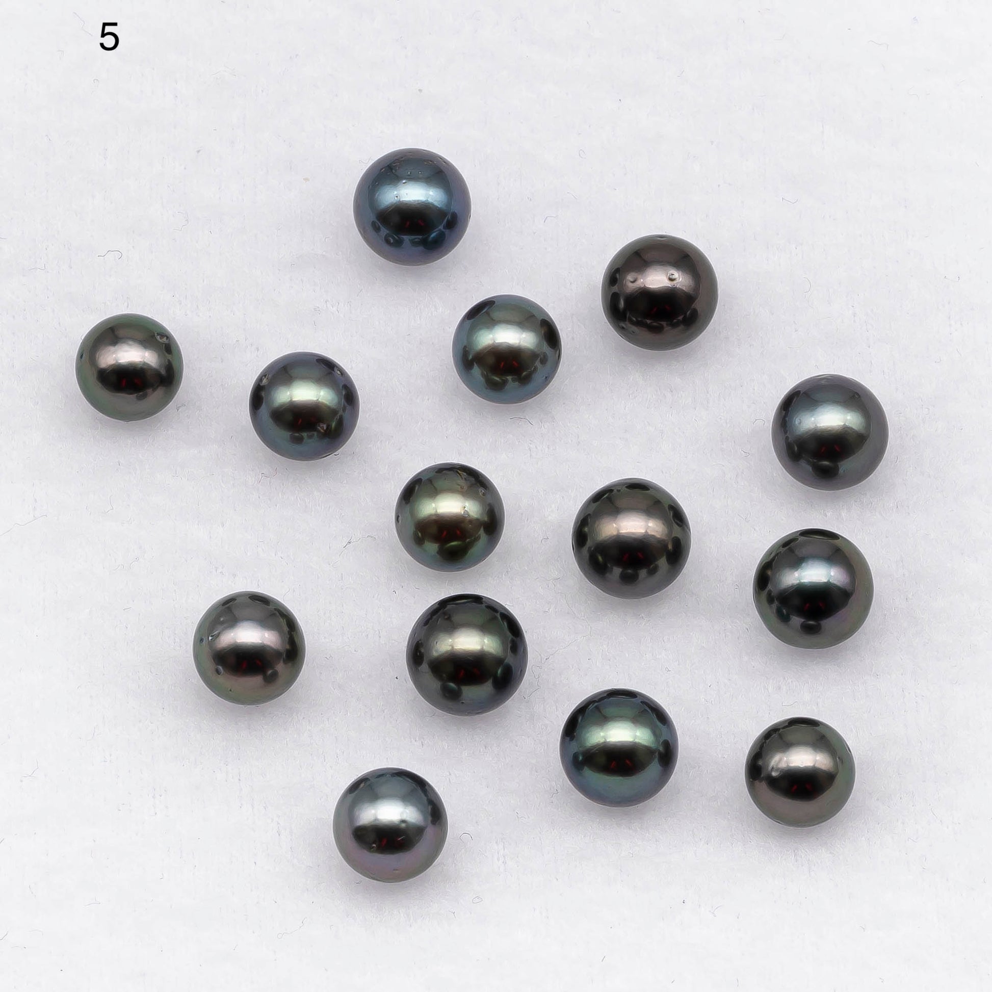 Loose round Tahitian pearl in blue or green color with blemishes 