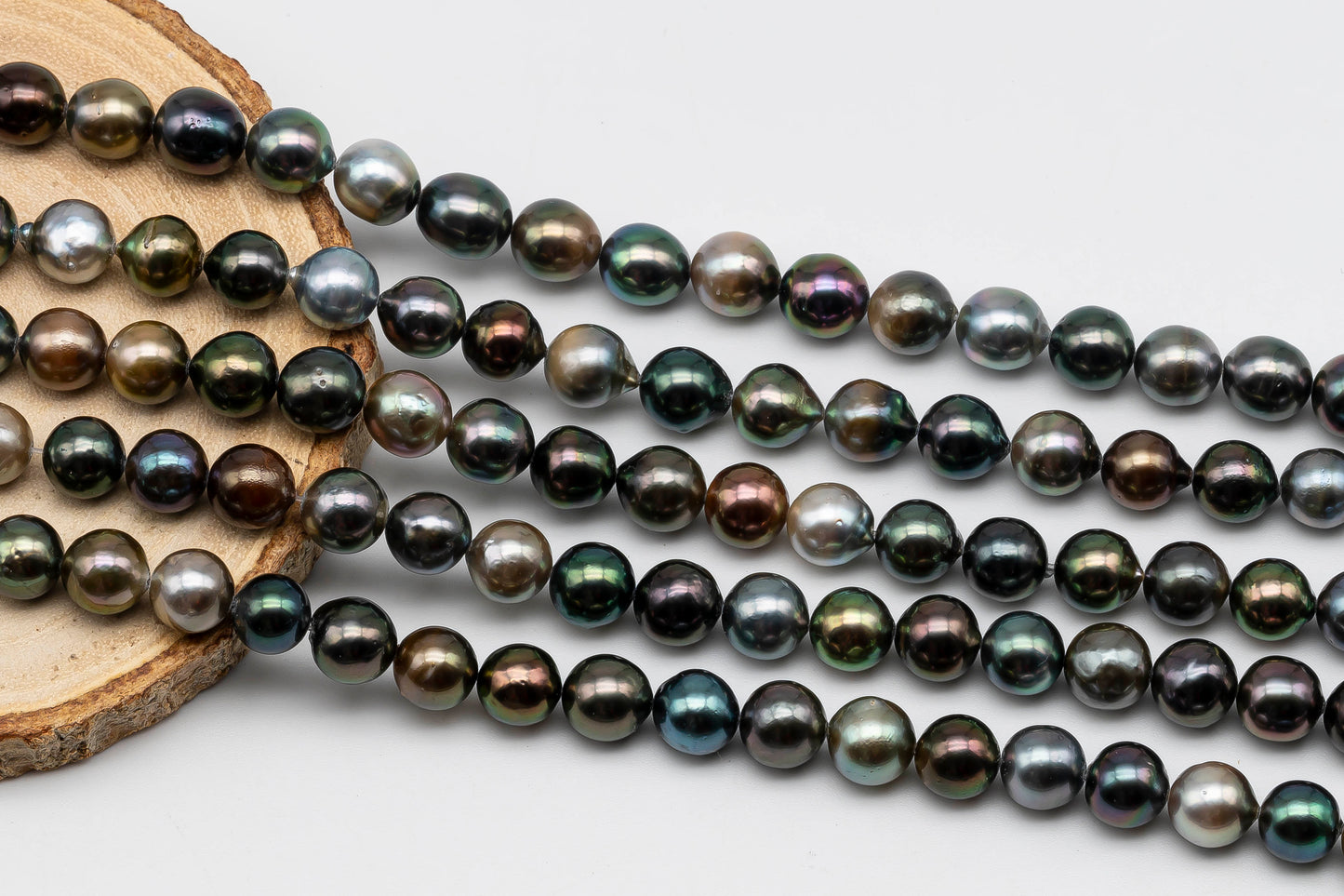 Tahitian Pearl in multi color stand display on top of a circle wood.