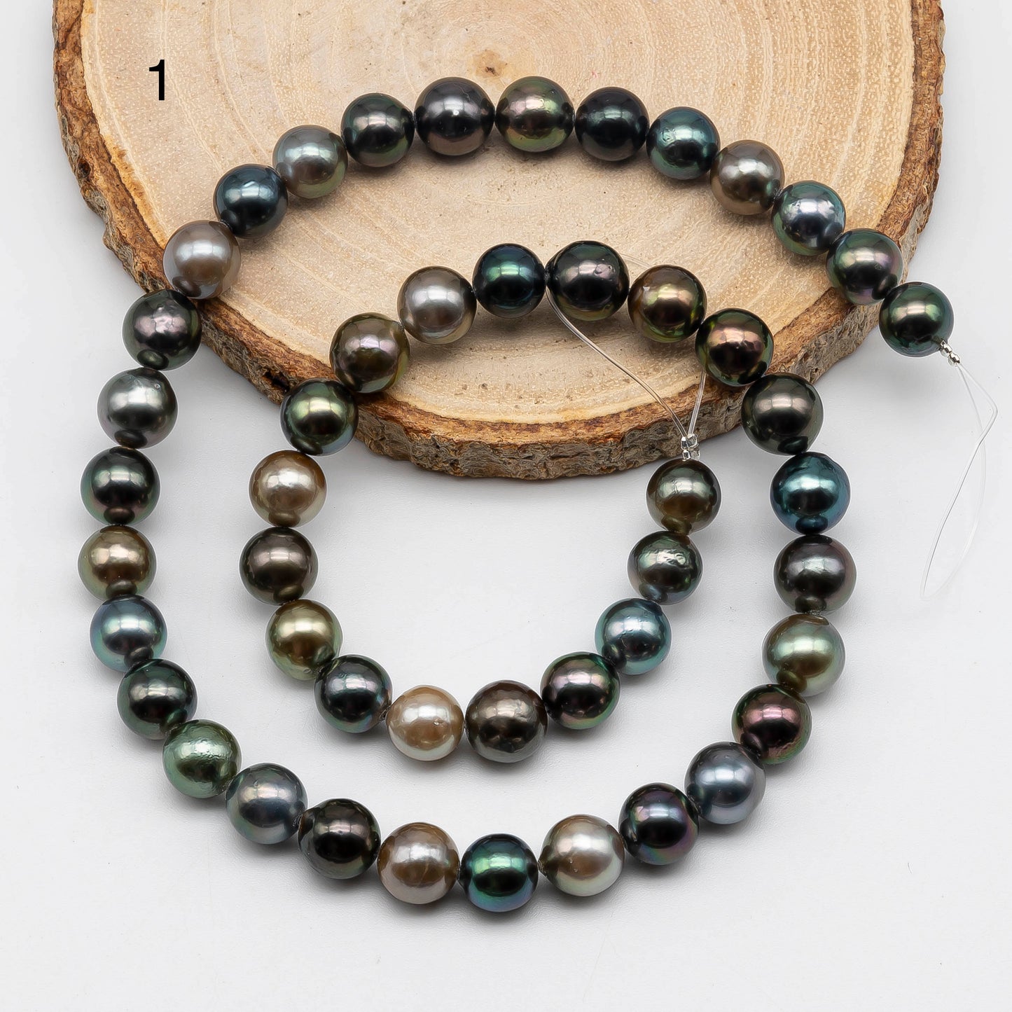 Multi Color Tahitian Pearl strand near round on top of the a wood display item number 1